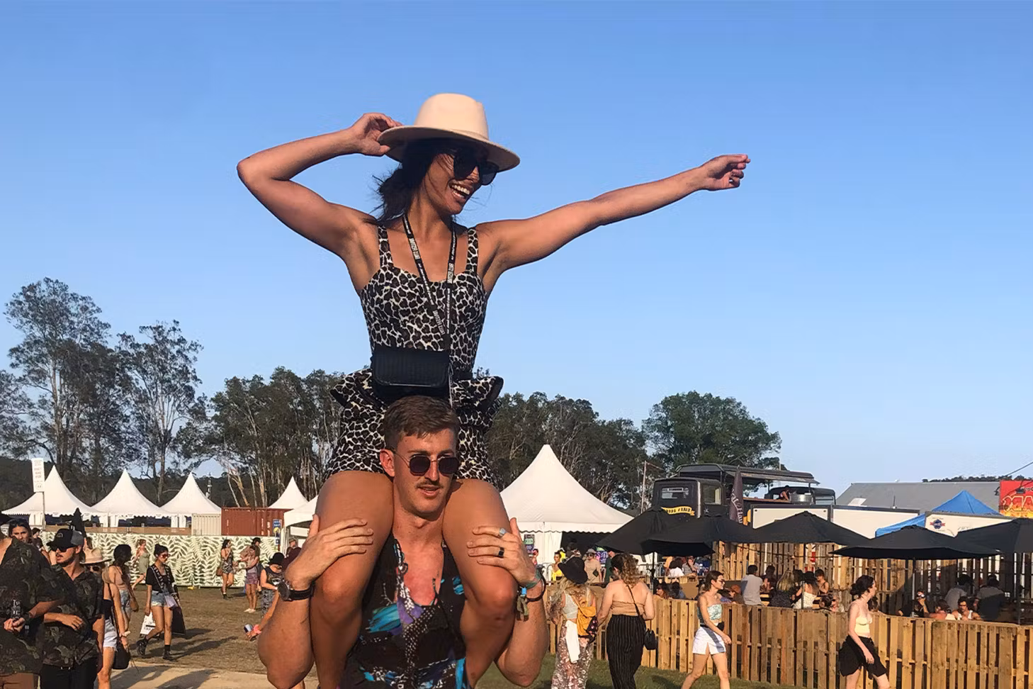 Man and woman on his shoulders at festival grounds